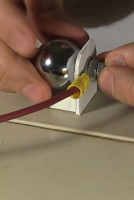 Screwing the metal ball to the high voltage wire.