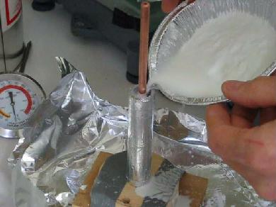 Pouring a barium titanate and wax mix into a mold for a
      cylindrical capacitor.
