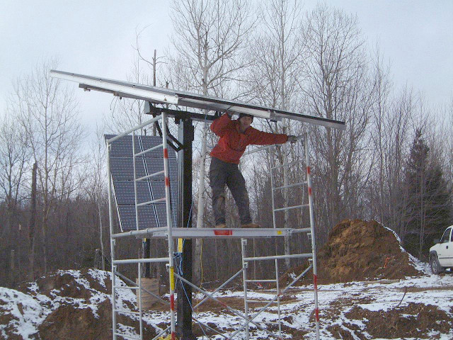 Installing solar power/photovoltaic panels on a winter day.