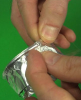 Taping the wire into ring and taping it to one end of the foil cylinder.