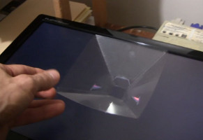 Putting the pyramid in place for displaying a hologram.