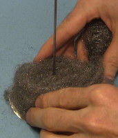 Wrapping the steel wool around the shaft for the stirling engine's displacer.