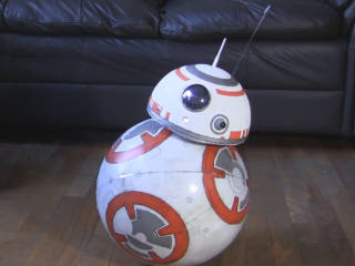 DIY BB-8 droid on the floor in front of a couch.