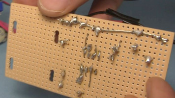 The soldering on the back of the perfboard for the crystal radio amplifier.