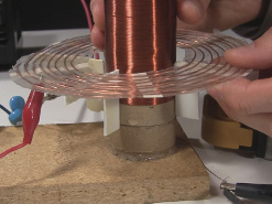 Changing the height of the spiral primary coil with respect to the secondary coil.