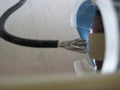 Sharp points of a wire spread apart and close to the Van de Graaff generator's belt.