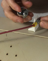 Attaching a metal ball to the high voltage wire.