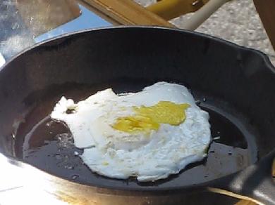 An egg cooking on my fresnel lens and mirror solar cooker setup.