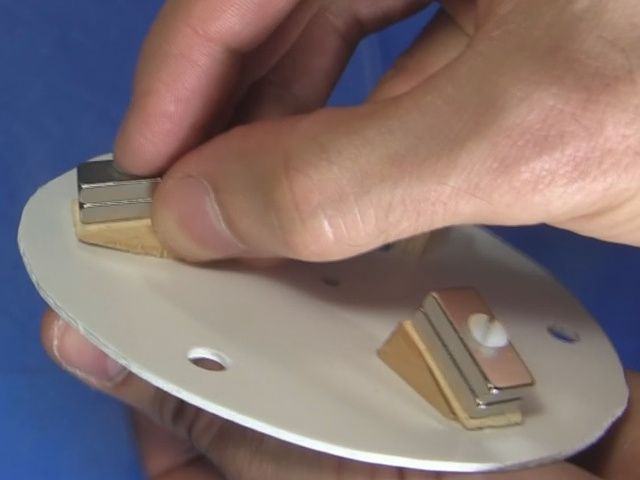 Attaching the magnets with their wooden wedges to the disk using nylon bolts.