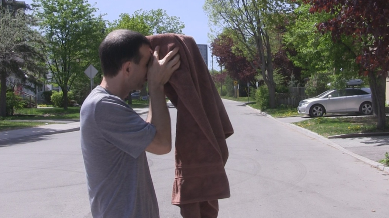 Covering the camera and my head in a towel to help block light from entering the pinhole camera through the cardboard.