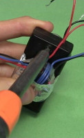 Screwing battery case closed.