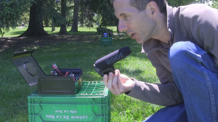 Speaking into the microphone to transmit sound using my 
      DIY/homemade laser communicator and showing the red laser spot
      on the receiver solar cell in the distance.