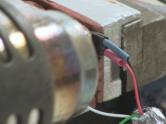 Close-up of heating the heat shrink tubing using the heat gun.