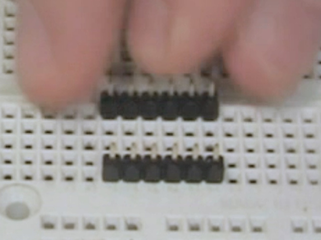 Putting male pin headers in a breadboard.