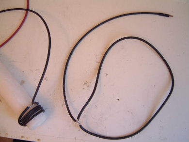 Wrapped a coil of insulated wire around the other end of the
wax candle dielectric and coated the soldered partion with liquid
electrical tape.
